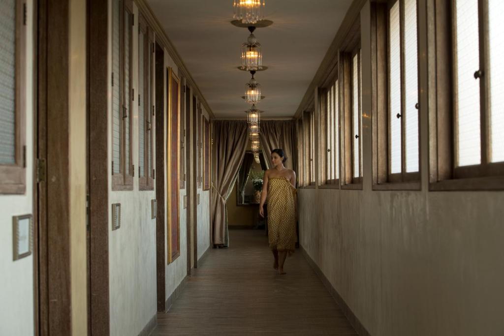 a woman walking down a hallway in a building at Amnaya Resort Kuta in Kuta