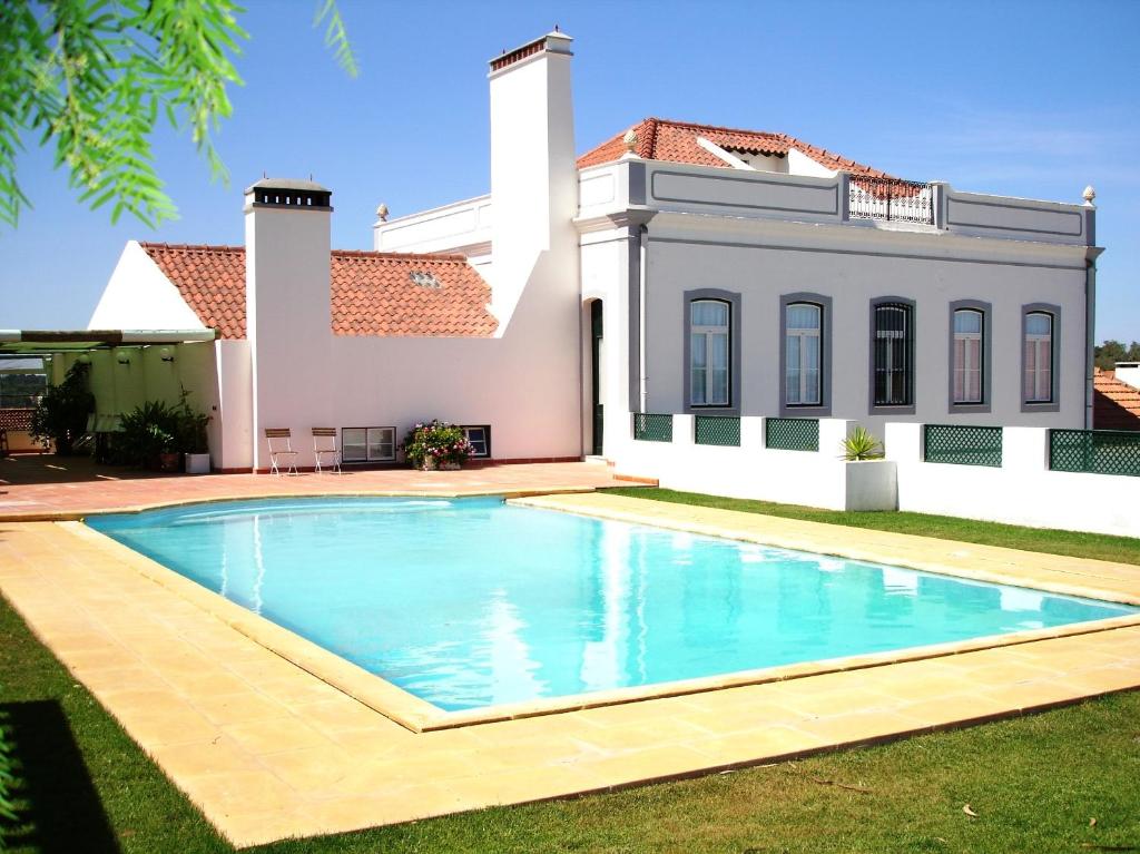a villa with a swimming pool in front of a house at Casa Do Lavre in Lavre