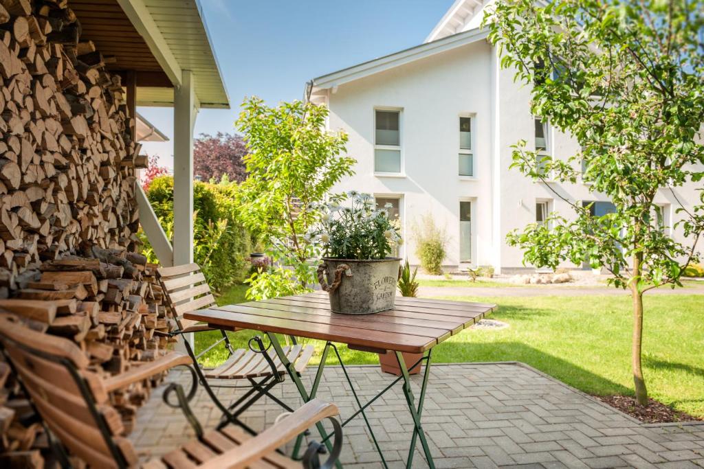 a patio with a wooden table and two chairs at Ferienwohnungen Buchenweg in Ostseebad Sellin