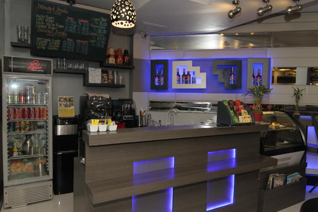 a bar in a restaurant with blue lights at Eloisa Royal Suites in Mactan