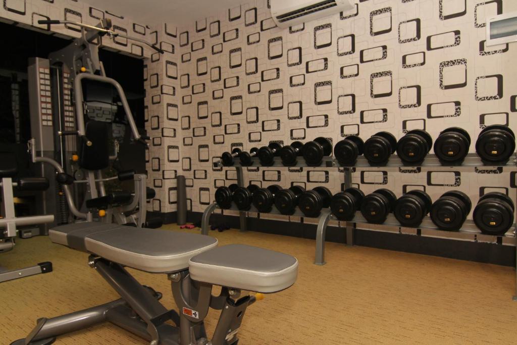 a gym with a row of dumbbells on a wall at Eloisa Royal Suites in Mactan