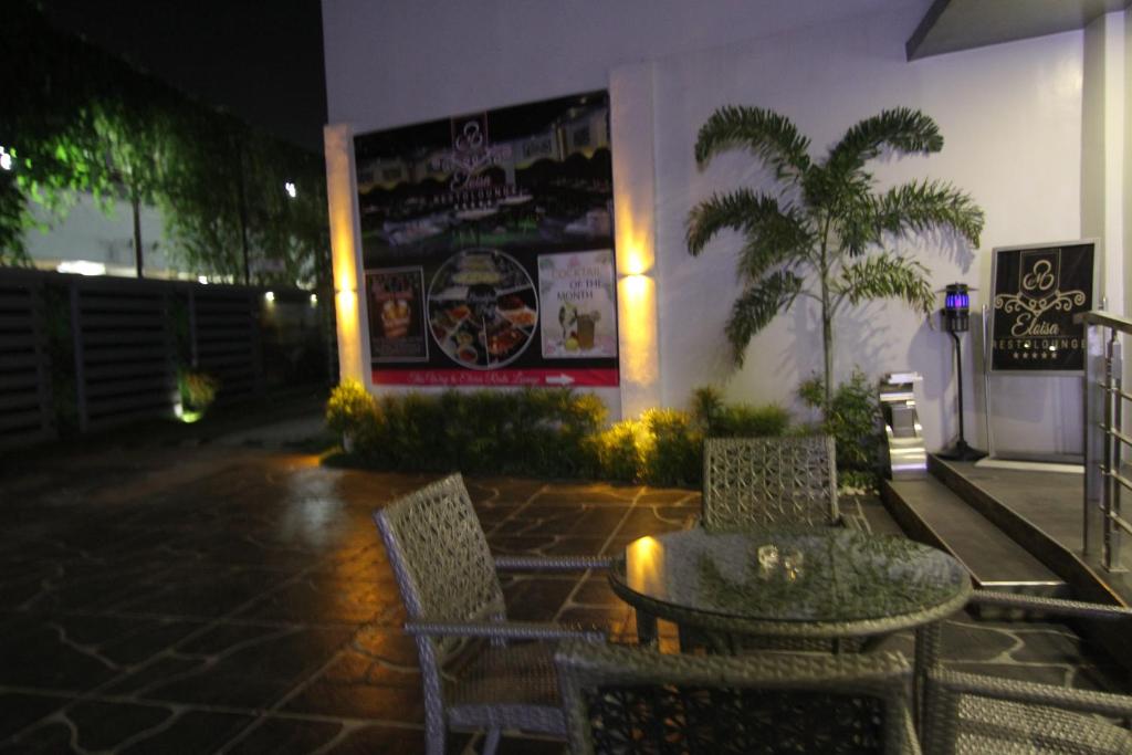 a patio with two chairs and a table in front of a building at Eloisa Royal Suites in Mactan