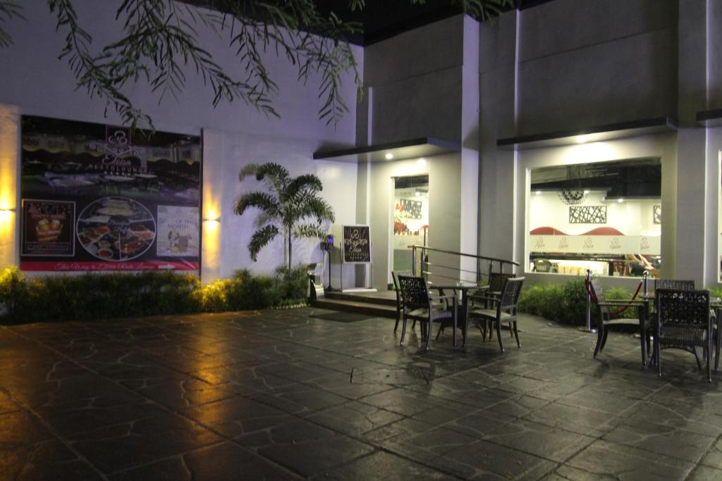 a patio with chairs and a table in front of a building at Eloisa Royal Suites in Mactan
