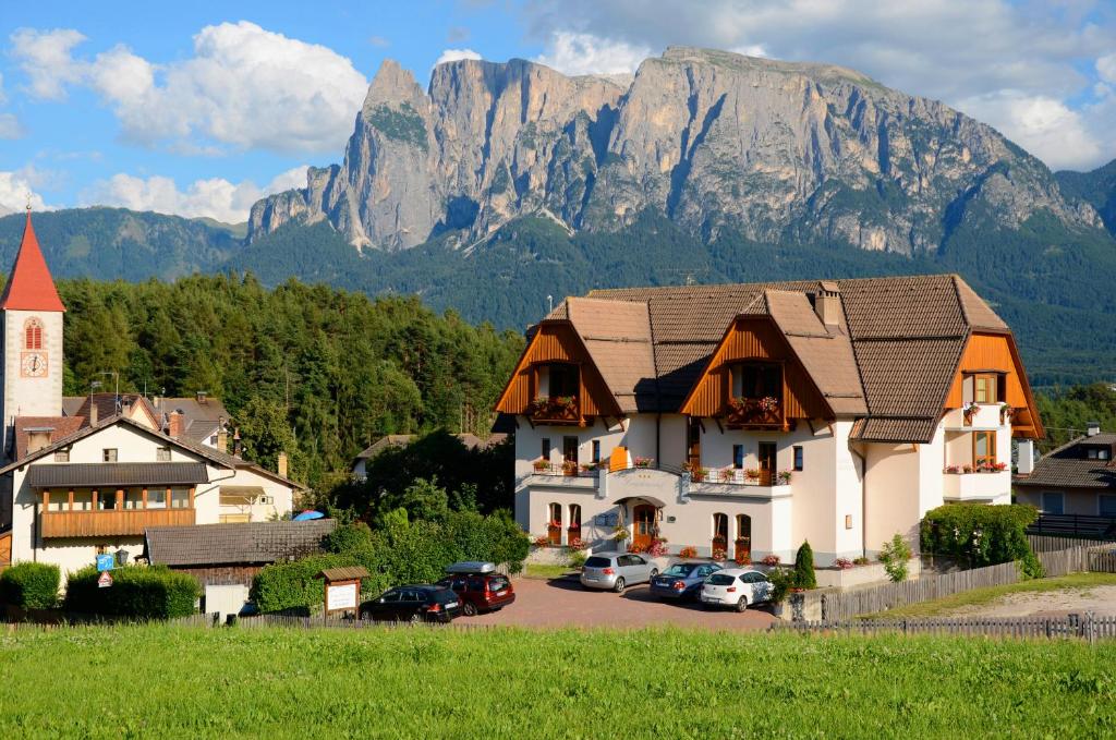 a large building with a mountain in the background at Hotel Lengsteinerhof in Longostagno