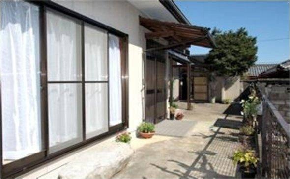 ein Haus mit großen Fenstern an der Seite in der Unterkunft Youyousanso Traditional B in Tsu