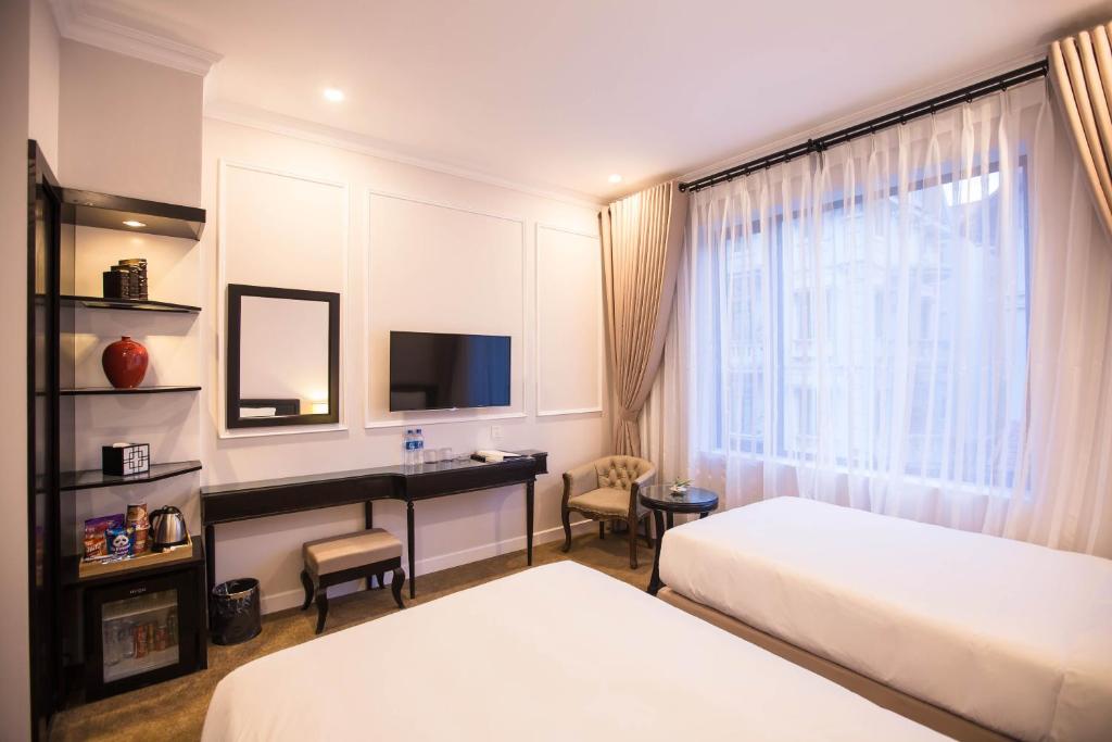 Postel nebo postele na pokoji v ubytování Dinh Elegant Hanoi Hotel