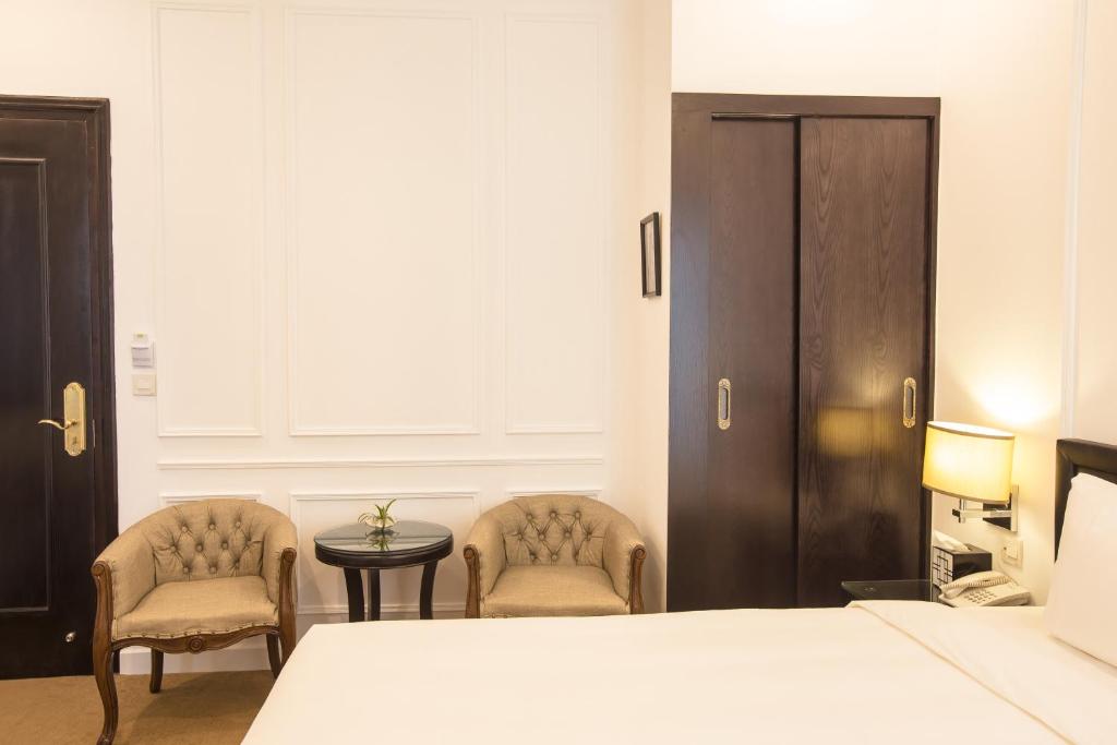 Postel nebo postele na pokoji v ubytování Dinh Elegant Hanoi Hotel