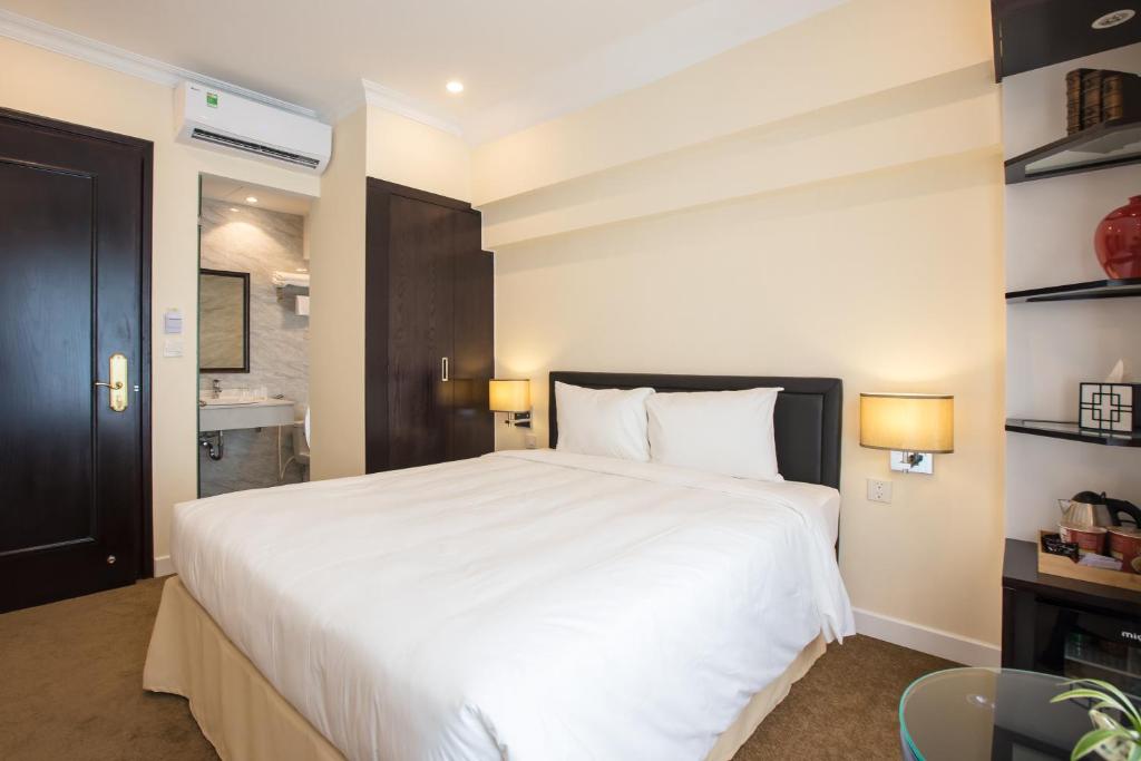 Postel nebo postele na pokoji v ubytování Dinh Elegant Hanoi Hotel