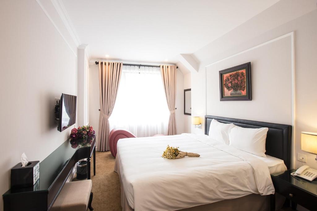 Postel nebo postele na pokoji v ubytování Dinh Elegant Hanoi Hotel