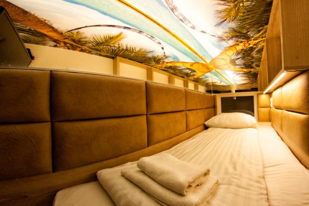 małe łóżko w pokoju z malowidłem na suficie w obiekcie Yourplace XXS Apartments w Krakowie