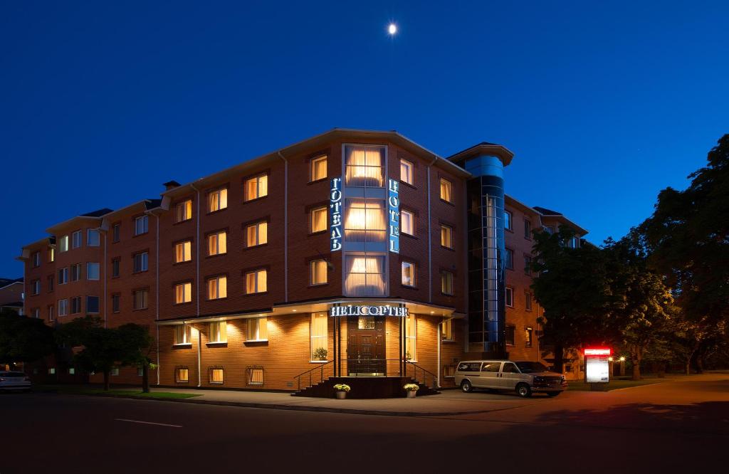 a building with a car parked in front of it at Hotel Helicopter in Kremenchuk