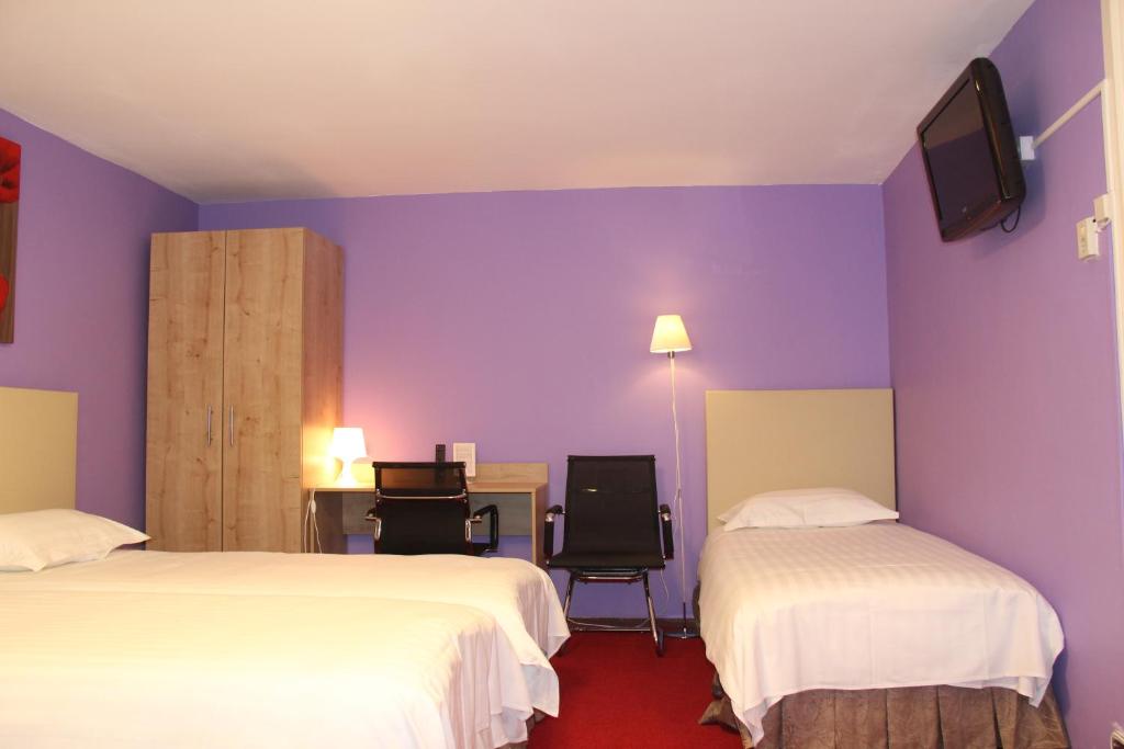 a hotel room with two beds and purple walls at New City Hotel Scheveningen in Scheveningen
