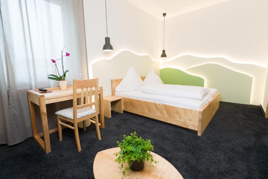 1 dormitorio con cama, escritorio y mesa en Hotel Rhönhof, en Hünfeld