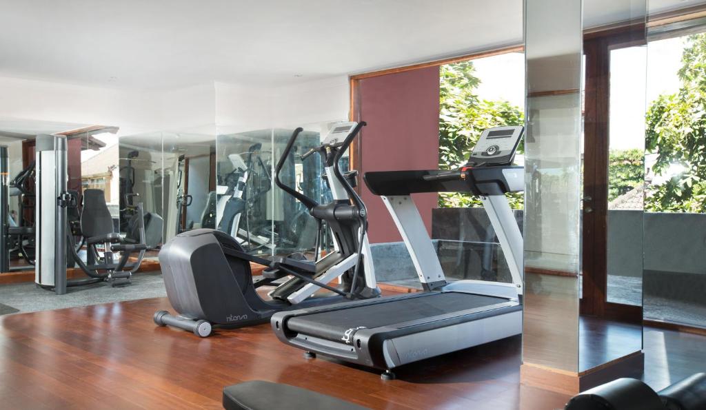 a gym with a treadmill and elliptical machines at Amnaya Resort Kuta in Kuta