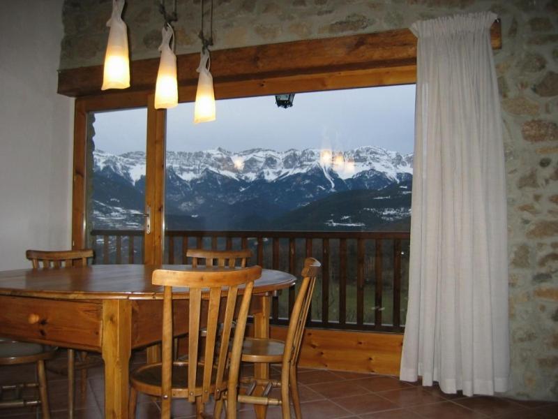 ein Esszimmer mit einem Tisch und Bergblick in der Unterkunft Cal Mateuet in Traveseres