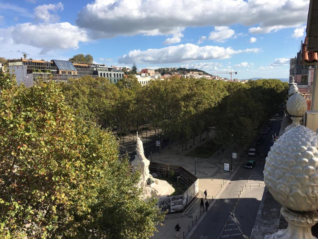 - une vue sur une rue bordée d'arbres et de bâtiments dans l'établissement Penthouse with a view in the centre, à Lisbonne