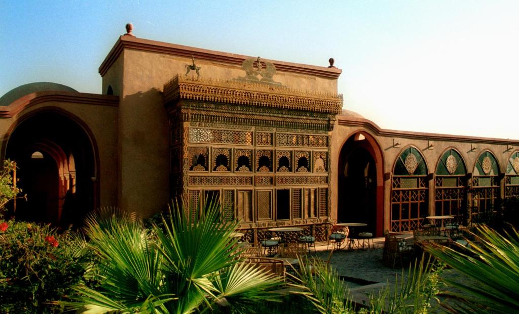 a building with an ornate balcony in a courtyard at Al Moudira Hotel in Luxor