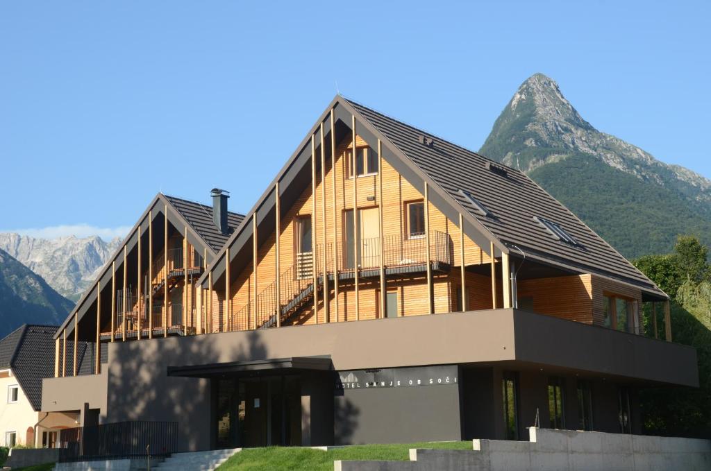
a large building with a view of a mountain range at Hotel Sanje ob Soči ***/**** in Bovec
