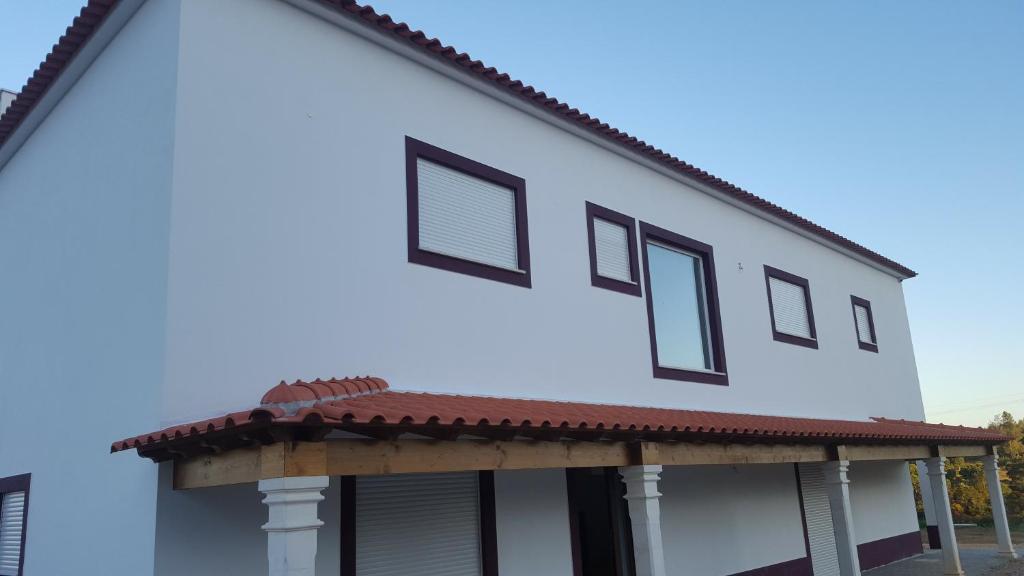 コンスタンシアにあるQuinta do Caneiro - Casa Turismo Ruralの白い窓と赤い屋根の白い家