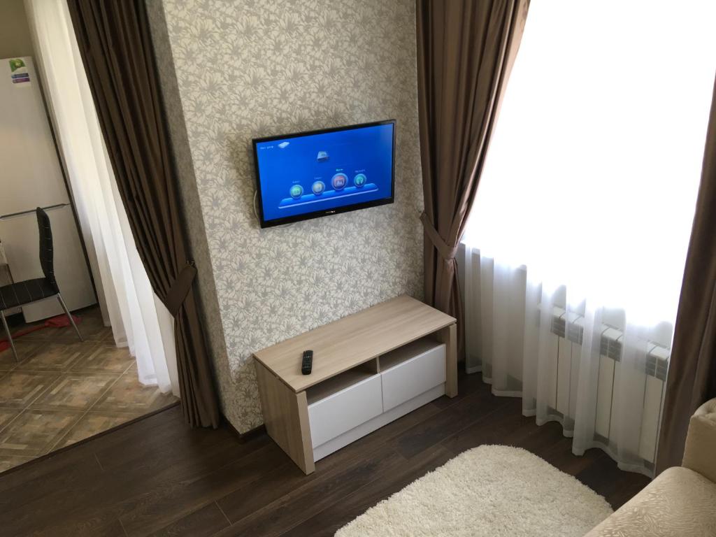 a living room with a tv on a wall at Apartament Berloga55 on 10 Let Oktiabria in Omsk