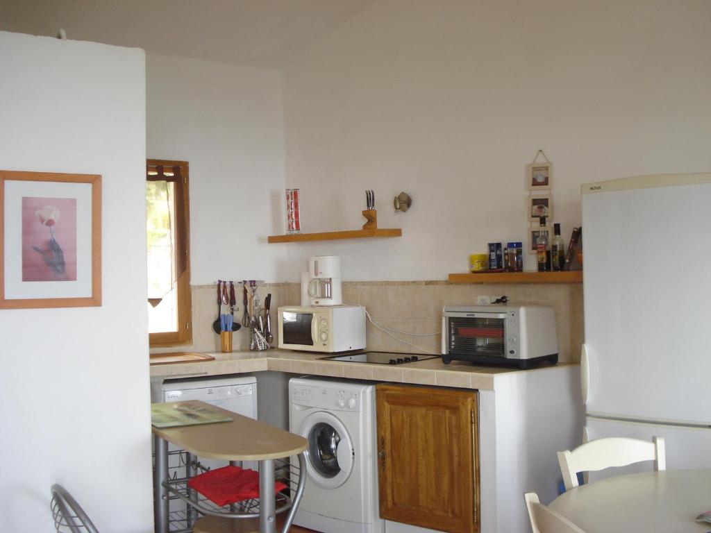 a kitchen with a refrigerator and a stove top oven at Gîte La Fontaine Corse in Loreto-di-Casinca
