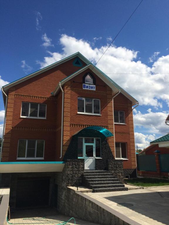 a brick building with a sign on it at Guesthouse Vizit in Chaykovskiy