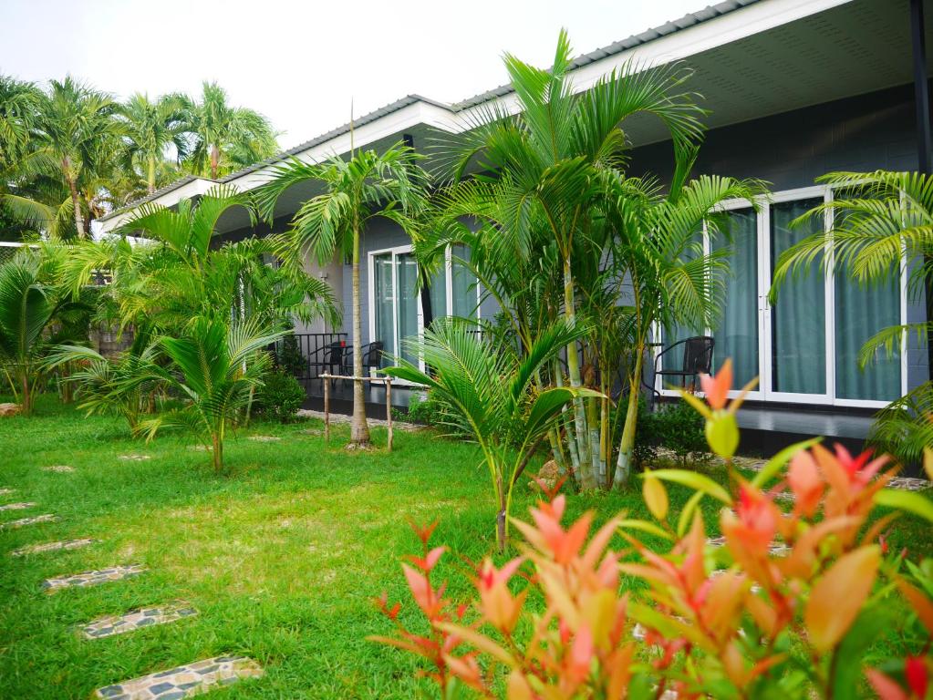 een huis met palmbomen ervoor bij Marisa Garden Bungalow in Bang Tao Beach