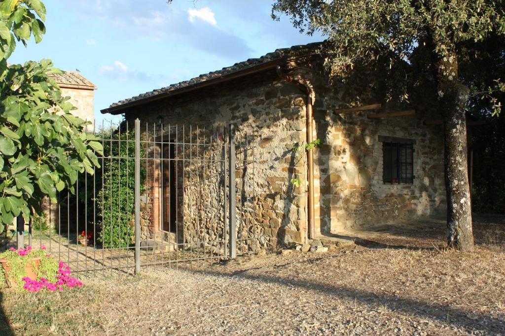a stone building with a fence in front of it at Annesso in Vagliagli