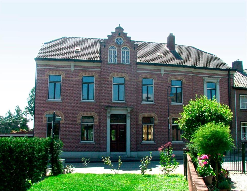 a red brick building with a clock on top of it at Rosa Arvensis in Lottum