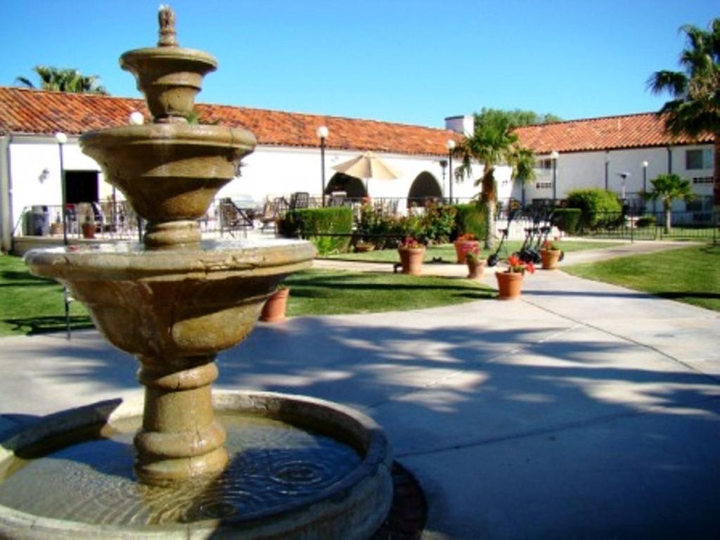 a fountain in the middle of a courtyard with a building at Historic Beaver Dam Lodge, Golf & RV Resort in Littlefield