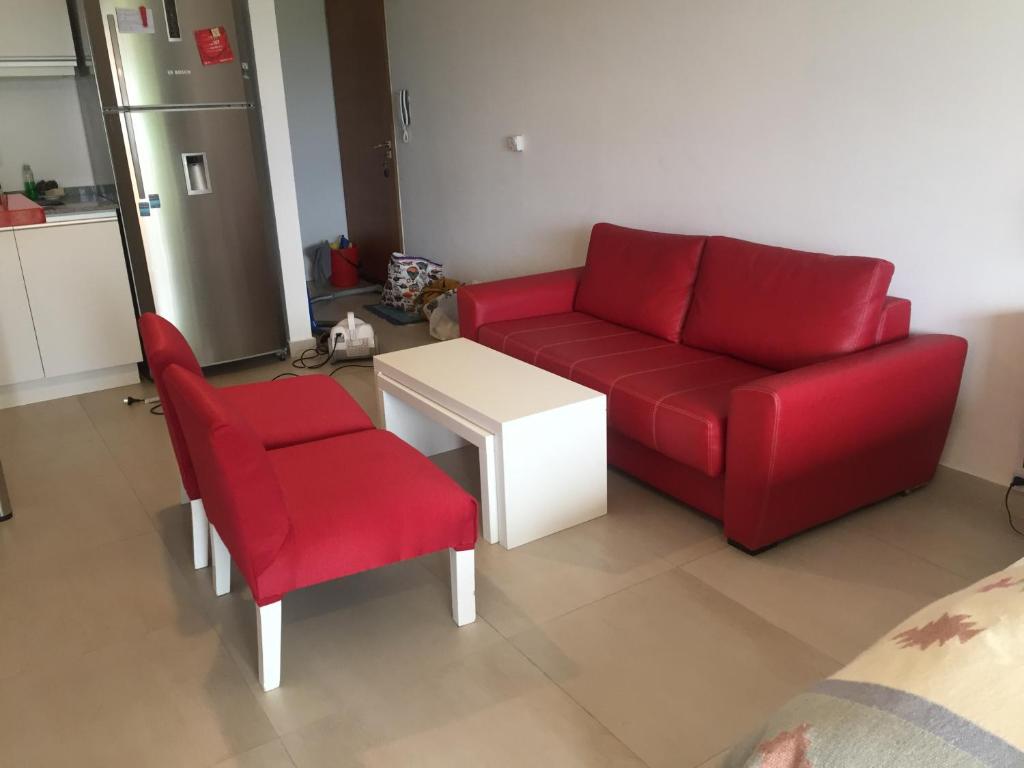 sala de estar con sofá rojo y silla en Departamento en Tigre con Pileta y cochera en Tigre