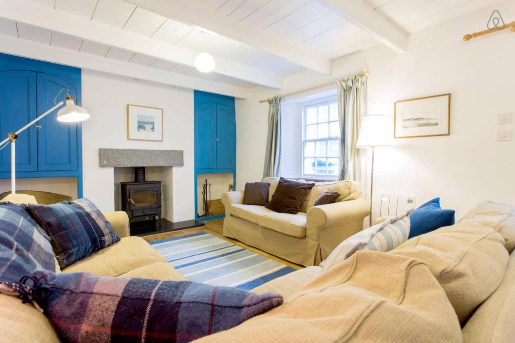 a living room with two couches and a fireplace at Fisherman's Cottage in Saint Mawes