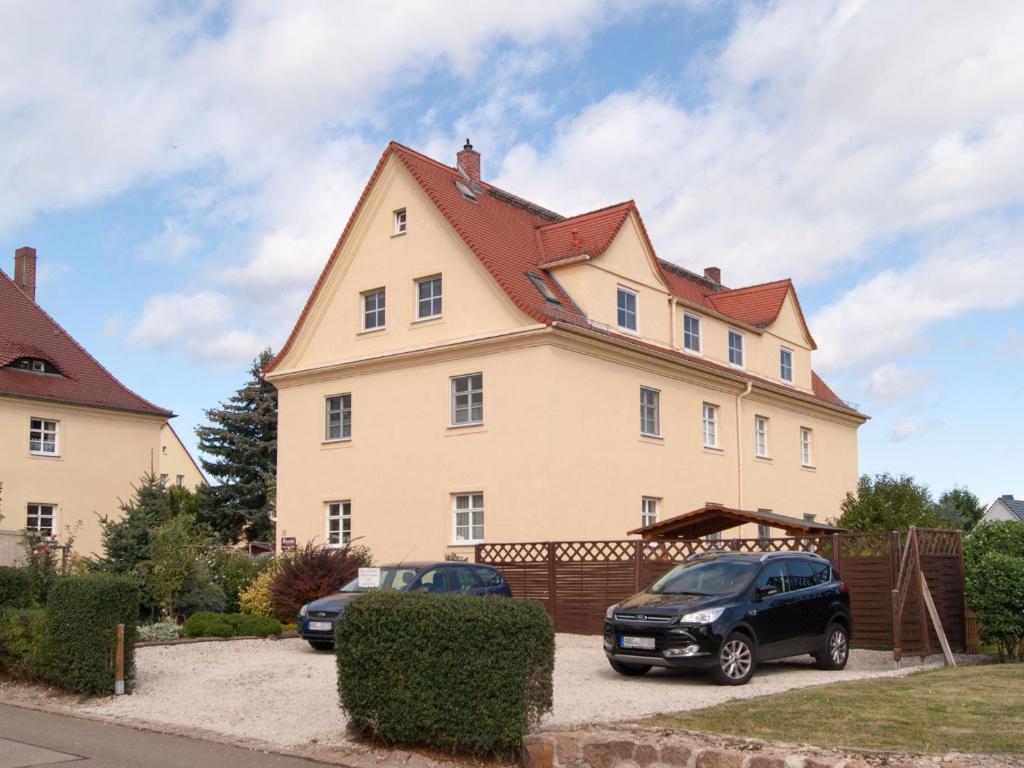una casa grande con dos coches estacionados frente a ella en Ferienwohnung Knoth, en Altemburgo