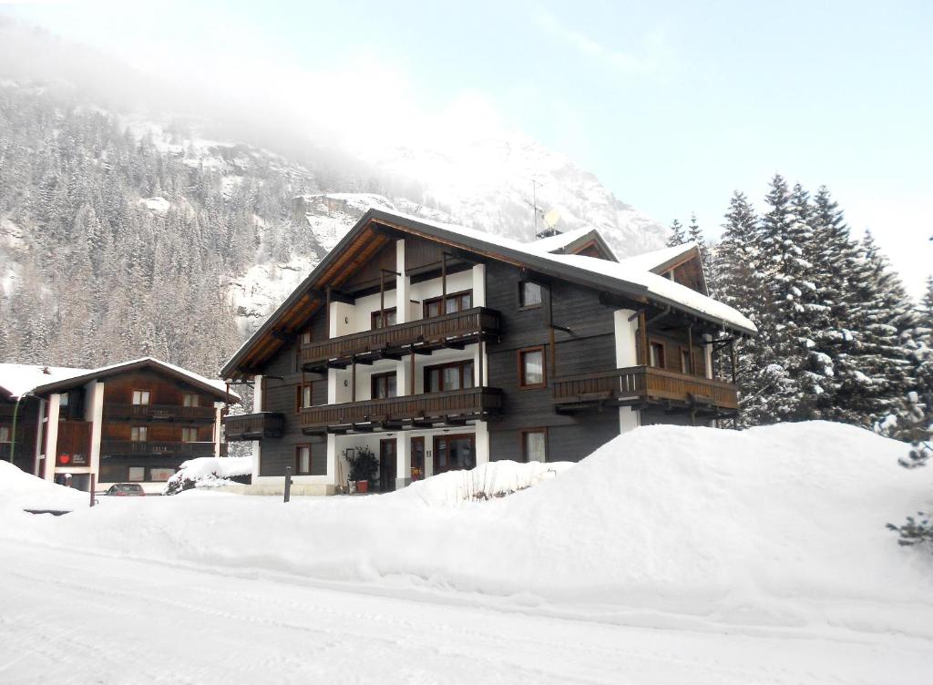 una cabaña de esquí con una pila de nieve delante de ella en Residence Apfel, en Gressoney-Saint-Jean