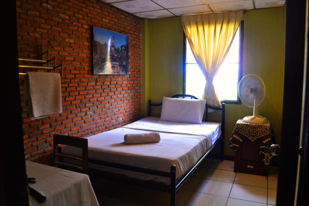 Habitación pequeña con cama y ventana en BRICKHOUSE Ayutthaya Guesthouse EST 1986, en Phra Nakhon Si Ayutthaya