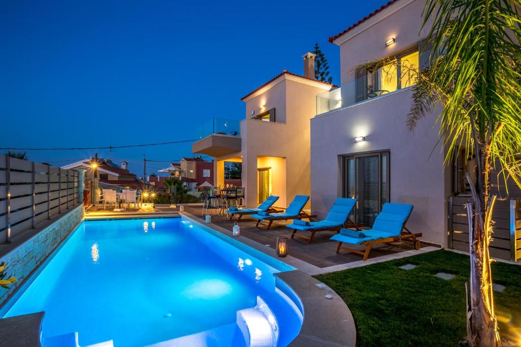 a villa with a swimming pool at night at Superior Villa Marina Mare with Sauna Hammam & Parking in Nea Kydonia