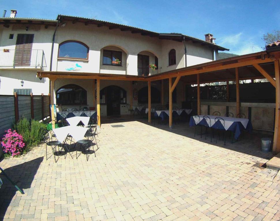 - un bâtiment avec une terrasse dotée de tables et de chaises dans l'établissement Locanda Dl'Angel, à Villar San Costanzo