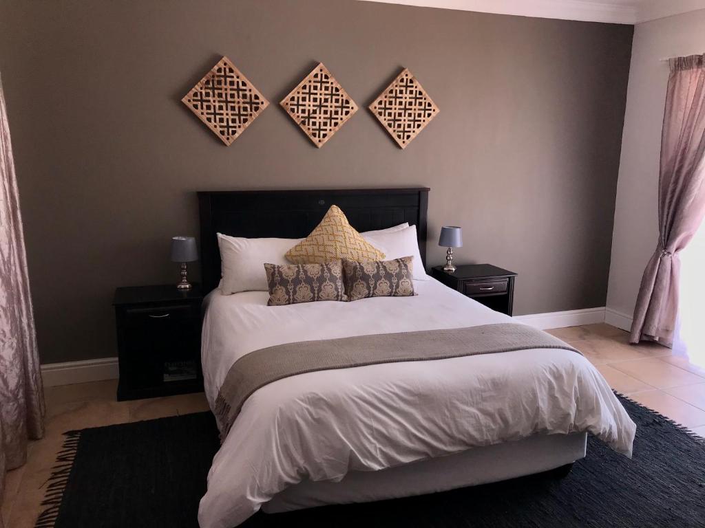 a bedroom with a large bed with two night stands at Bird's View in Hermanus