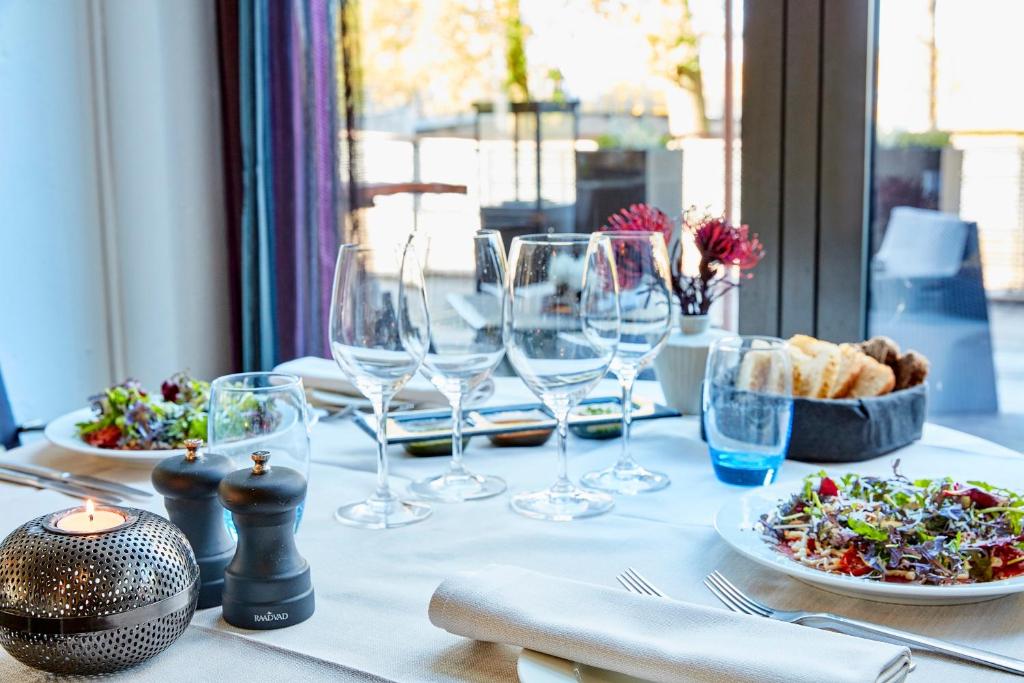 un tavolo con bicchieri da vino e un piatto di cibo di Radisson Hotel Papirfabrikken Silkeborg a Silkeborg
