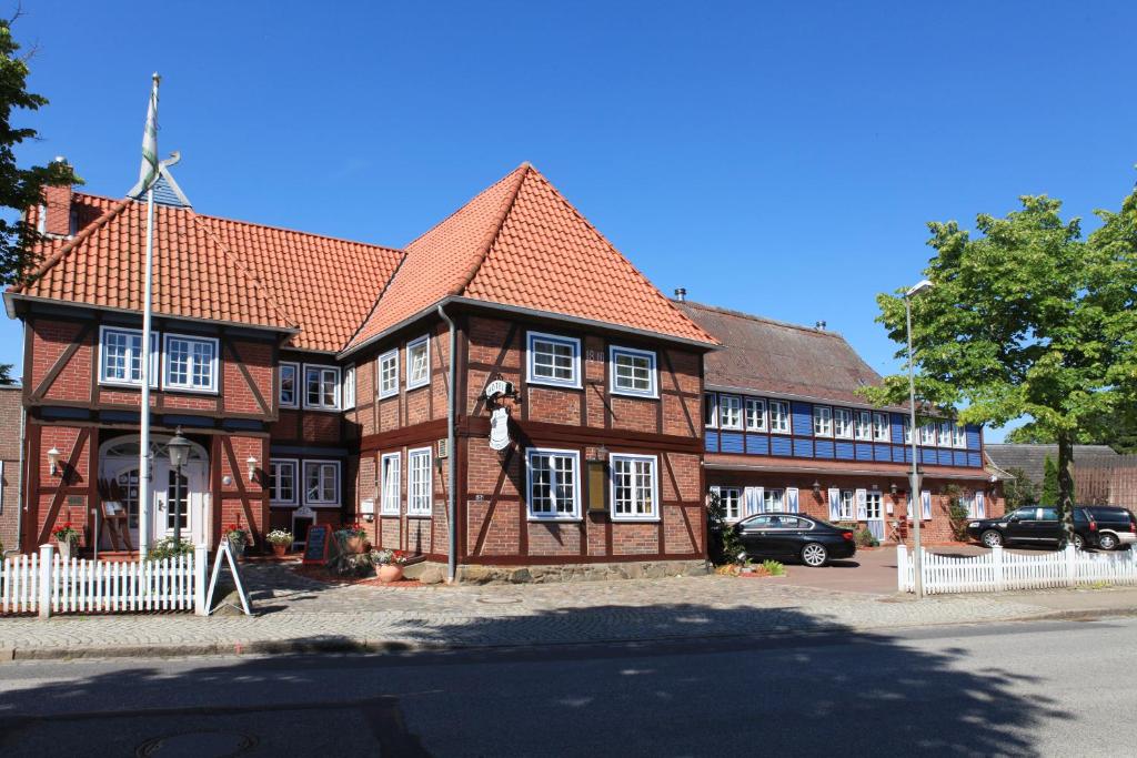 a brick building with a clock on the front of it at Landhotel Klempau in Lübeck