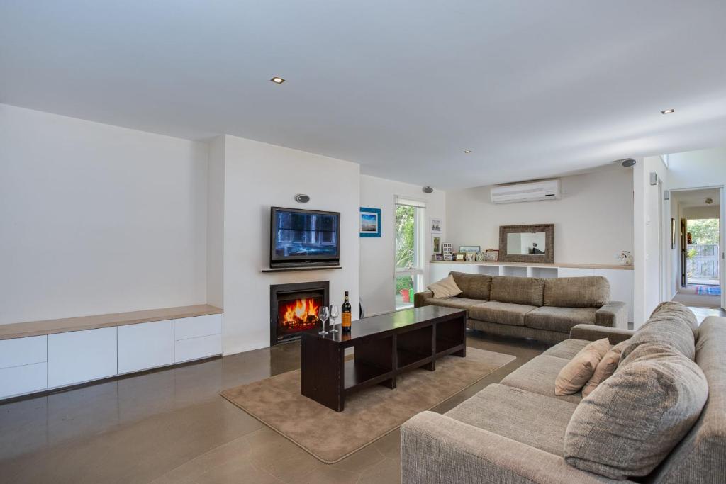 a living room with a couch and a fireplace at Portsea Place in Portsea
