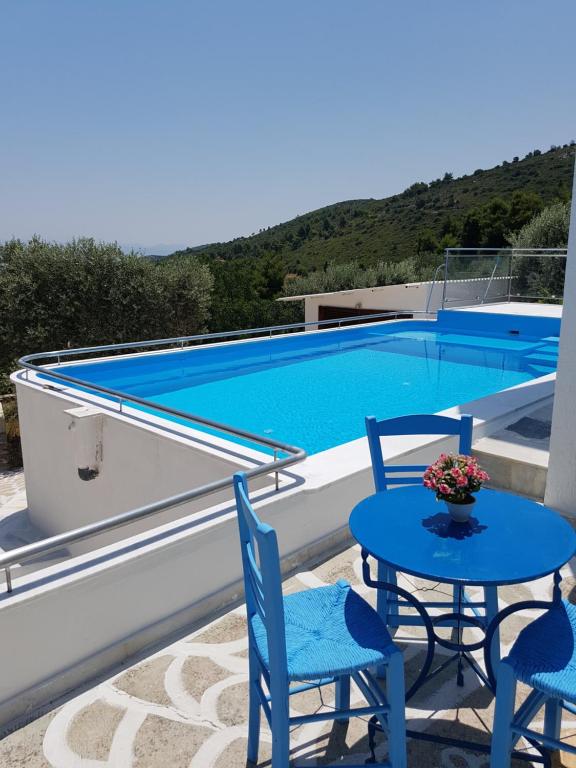 a patio with a table and chairs and a swimming pool at Villa Konaki in Grammatiko