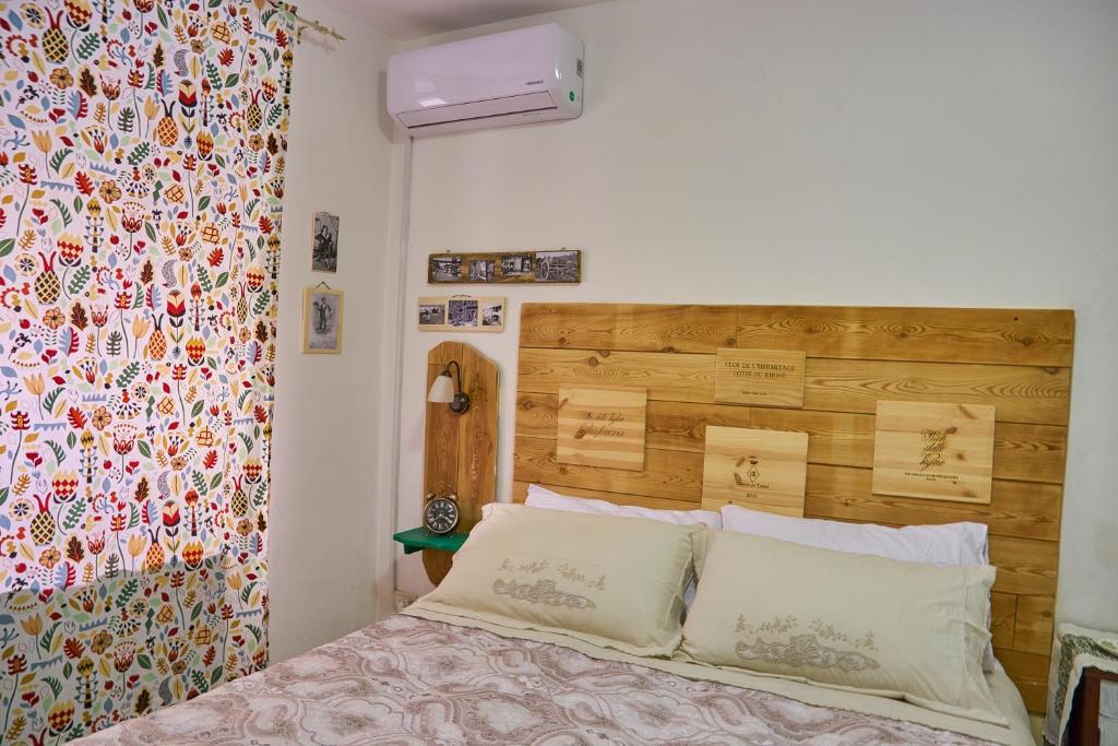 Licodia Eubeaにあるe ci rivo' giùのベッドルーム1室(木製ヘッドボード付きのベッド1台付)