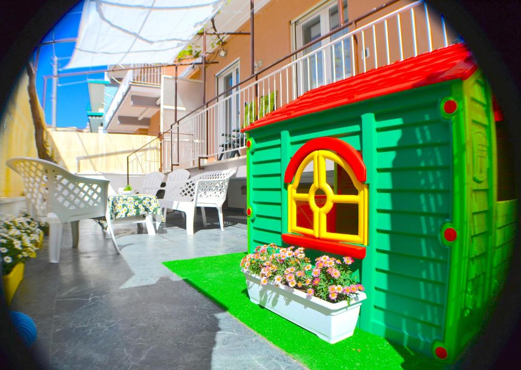 una casa de juguete con ventana y flores en un patio en Gaeta in Vacanza - Esclusivo App. sulla Spiaggia, en Gaeta