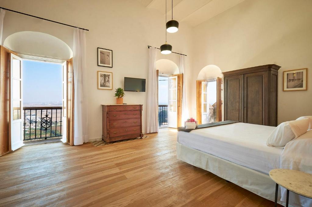 a large bedroom with a bed and a balcony at Bekkeh Posada Boutique in Vejer de la Frontera