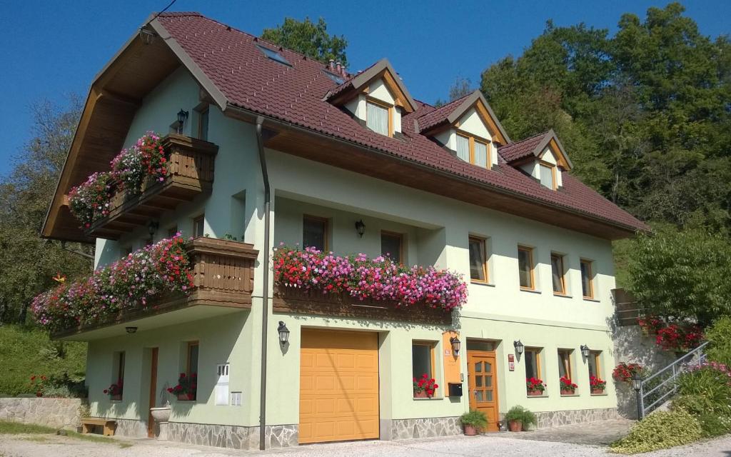 une maison avec des boîtes de fleurs sur son côté dans l'établissement Apartmaji Hribar Pr'Ostank, à Kamnik