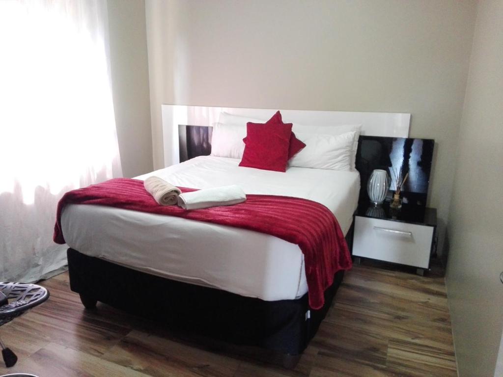 a bedroom with a large white bed with red pillows at Angel Guest House in Maputo