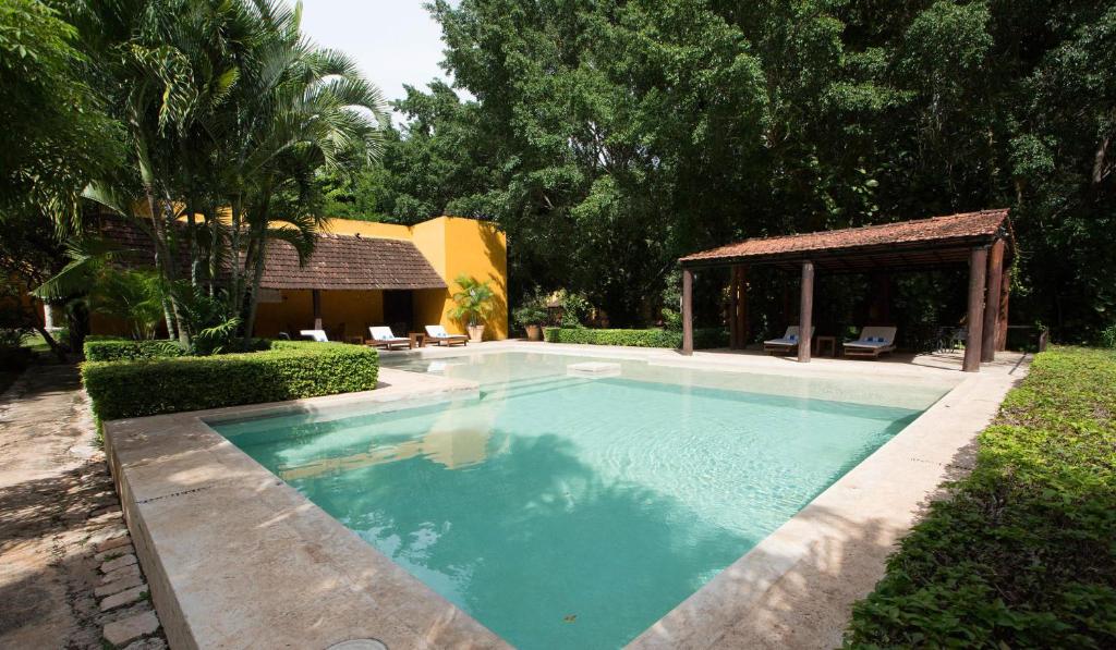 a swimming pool in a yard with a gazebo at Hacienda Misne in Mérida
