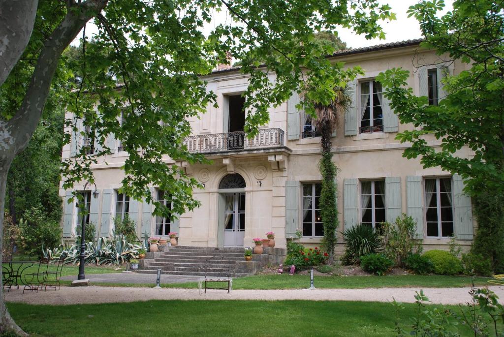 een oud huis met een trap en een bankje ervoor bij Château Juvenal in Saint-Hippolyte-le-Graveyron