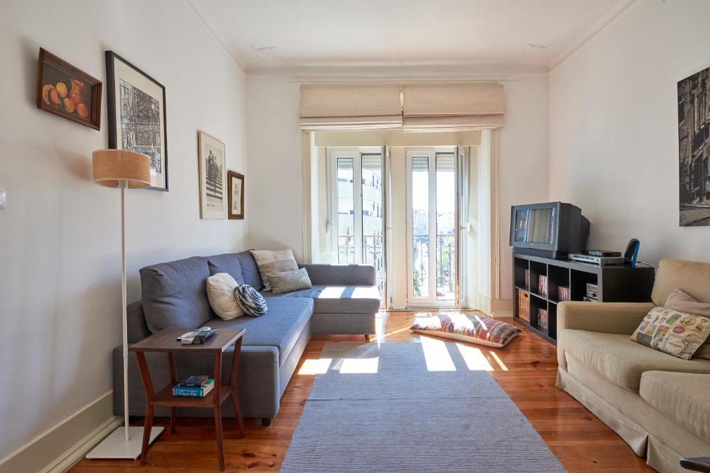un soggiorno con divano e tavolo di Charming Apartment Marquês a Lisbona